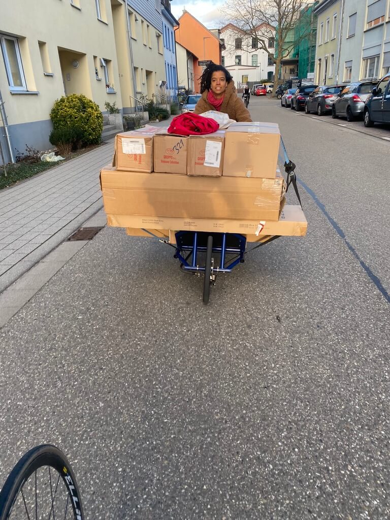 A girl riding the hara cargo in the streets loaded many packages